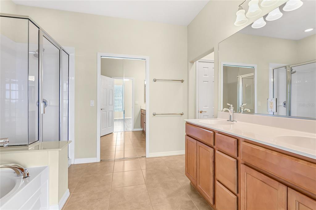 5677 Fossano Drive, Unit 506 Sarasota, FL 34238 - Photo 19 of 44 a spacious bathroom with a mirror sink and shower