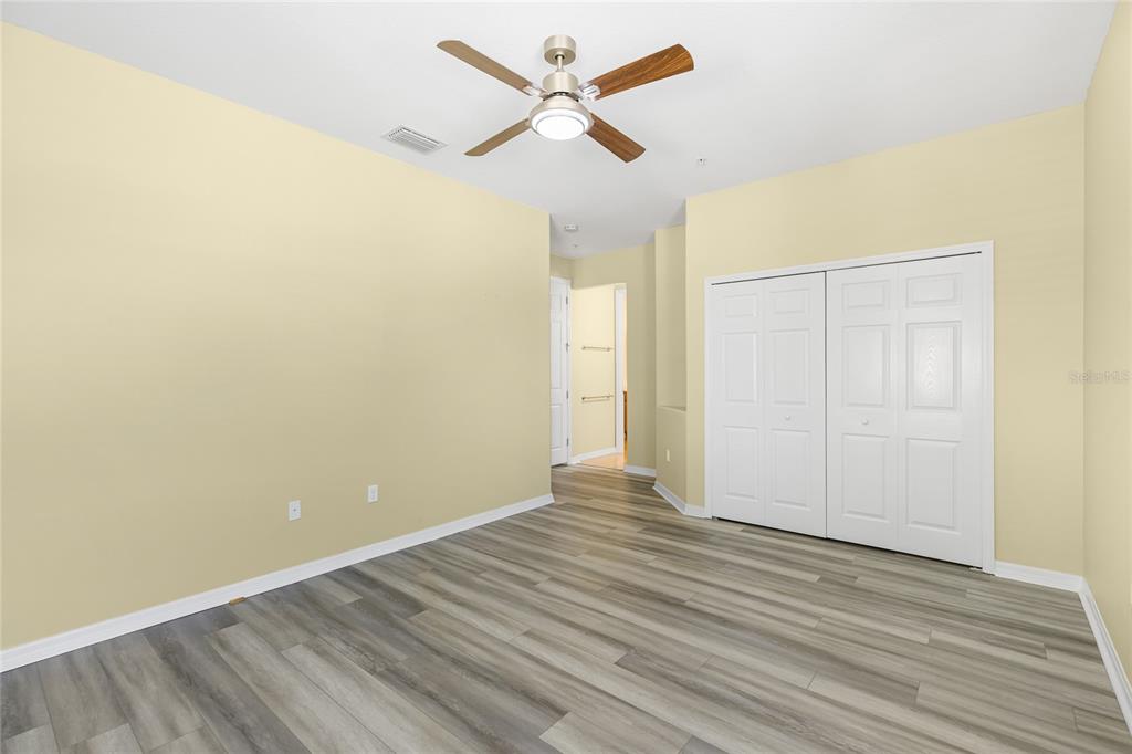 5677 Fossano Drive, Unit 506 Sarasota, FL 34238 - Photo 24 of 44 an empty room with wooden floor and a ceiling fan