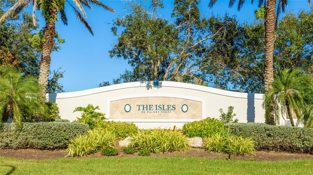 5677 Fossano Drive, Unit 506 Sarasota, FL 34238 - Photo 29 of 44 a sign of golf club on a wall under a tree