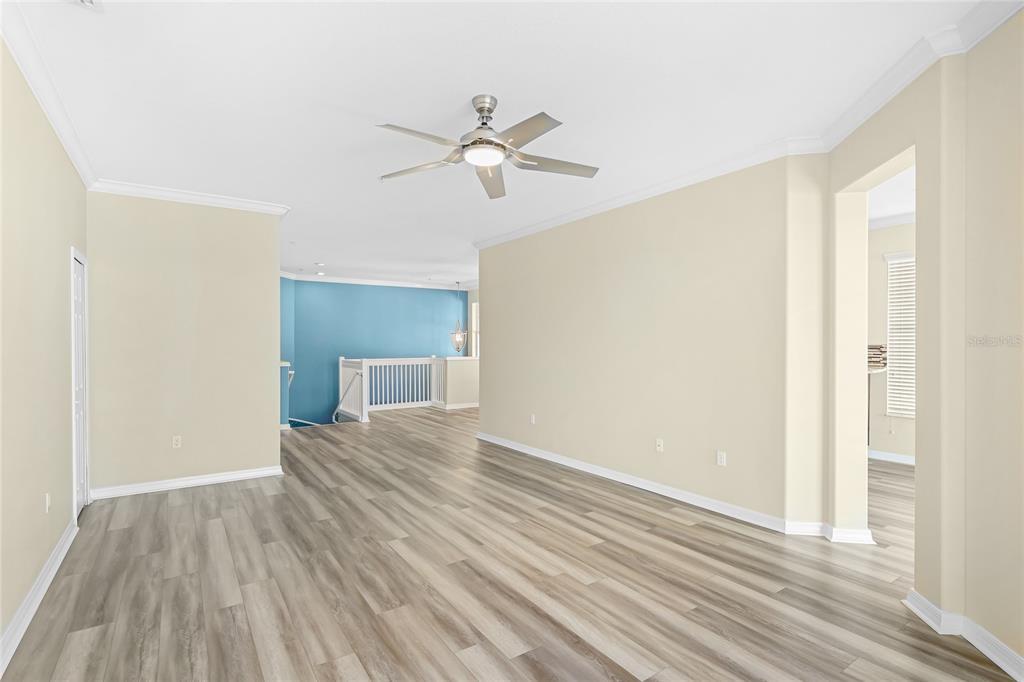 5677 Fossano Drive, Unit 506 Sarasota, FL 34238 - Photo 8 of 44 a view of empty room with wooden floor and fan