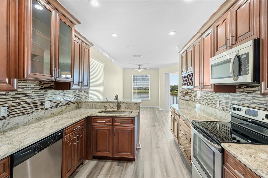 5677 Fossano Drive, Unit 506 Sarasota, FL 34238 - Photo 9 of 44 a kitchen with stainless steel appliances granite countertop a stove and a sink
