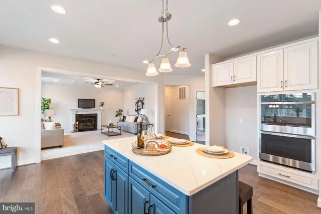 a room with stainless steel appliances kitchen island granite countertop a stove a sink a dining table and chairs