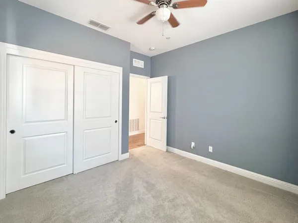 an empty room with a ceiling fan and window