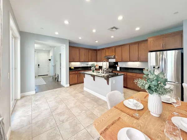 a kitchen with stainless steel appliances granite countertop a refrigerator and a sink