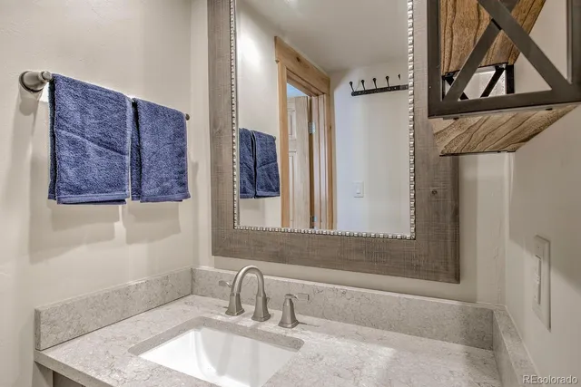 a bathroom with a granite countertop sink a mirror and shower