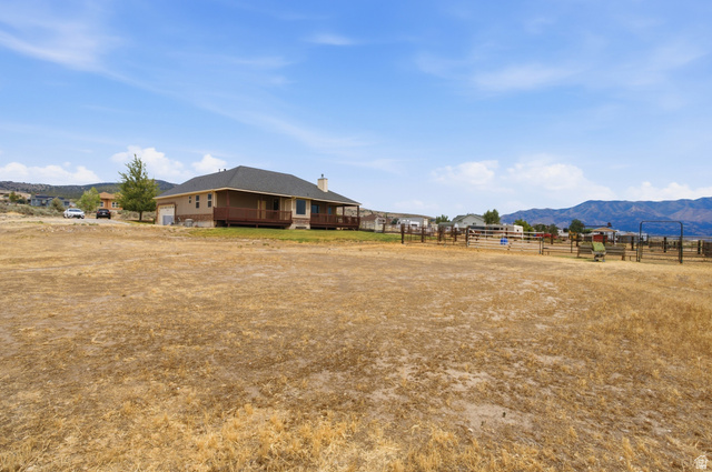 2567 West Rim Rock Drive Stockton, UT 84071 - Photo 47 of 64 Expansive land parcel featuring a ranch-style home with a dark shingle roof and a full-length wooden deck