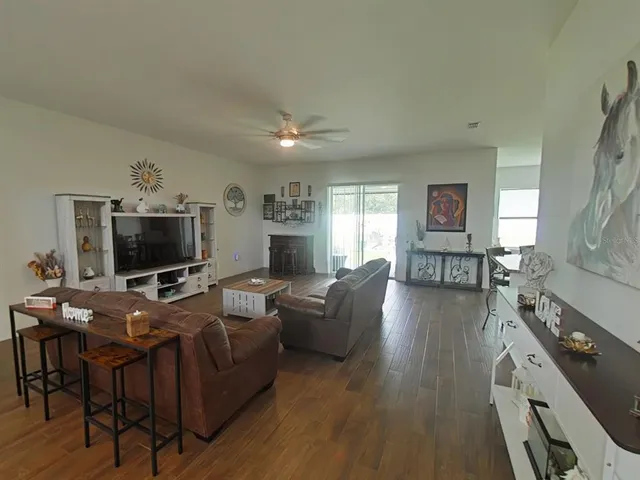 a living room with furniture and a view of kitchen
