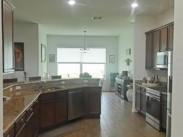 a view of a dining room with furniture a chandelier and wooden floor
