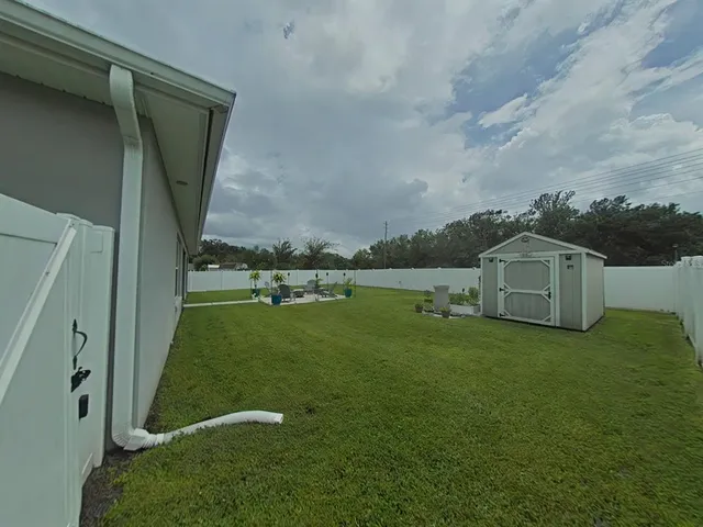 a backyard of a house with table and chairs