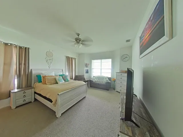 a spacious bedroom with a bed and a couch