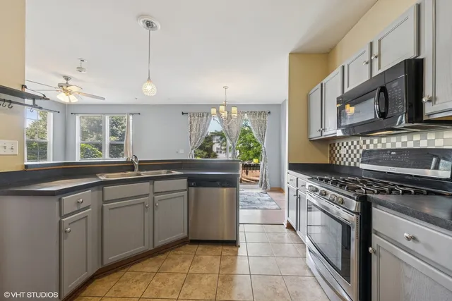 a kitchen with stainless steel appliances granite countertop a stove a sink and a microwave