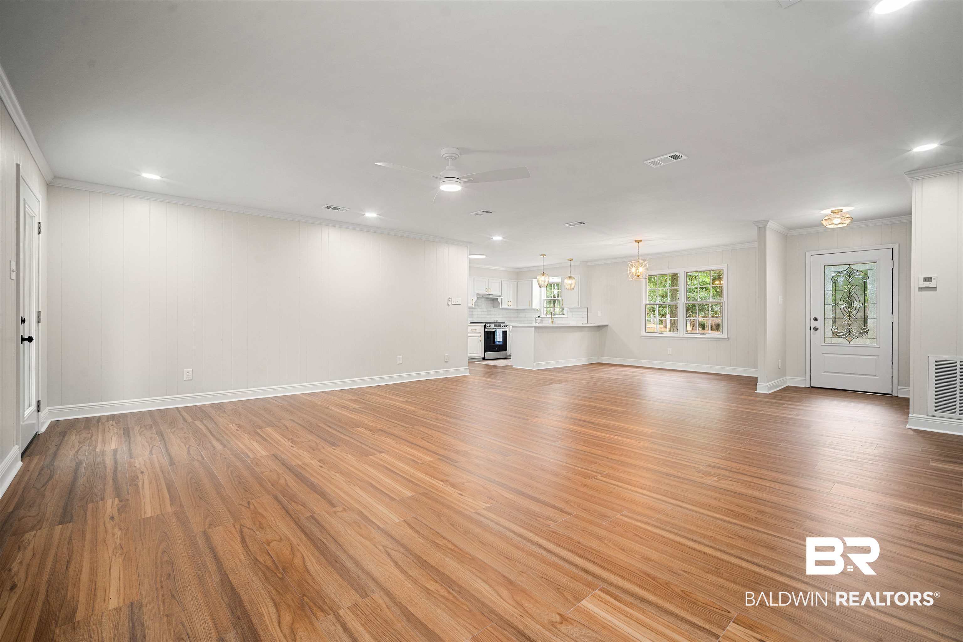 3050 Lacoste Road Mobile, AL 36618 - Photo 7 of 30 Unfurnished living room featuring crown molding, light wood finished floors, a ceiling fan, recessed lighting, and a chandelier