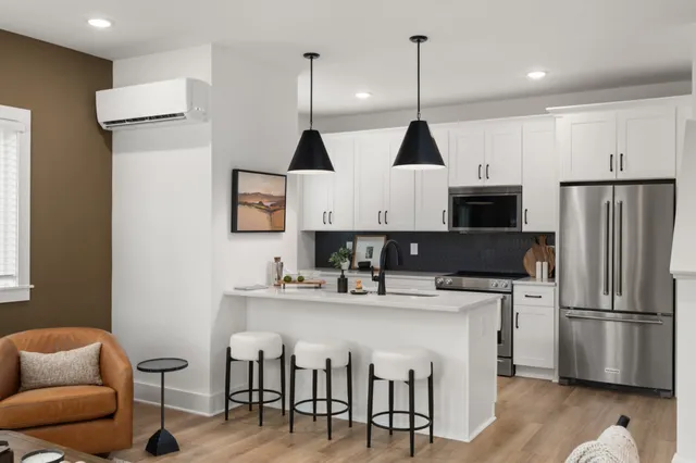 a kitchen with stainless steel appliances granite countertop a sink a stove a refrigerator and island with wooden floor