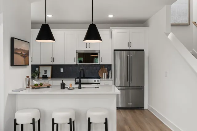 a kitchen with kitchen island white cabinets and refrigerator