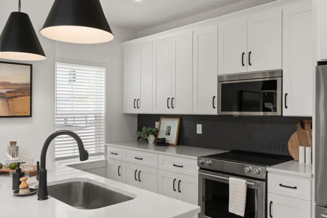 a kitchen with stainless steel appliances a stove a sink a refrigerator and cabinets