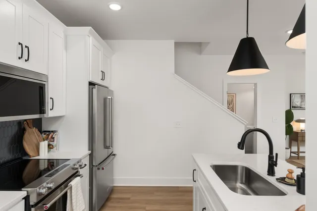 a kitchen with a sink a stove and a microwave
