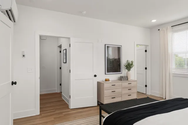 a bedroom with a bed and wooden floor