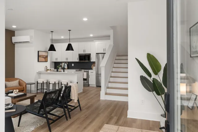 a kitchen with stainless steel appliances kitchen island granite countertop a table chairs and a refrigerator