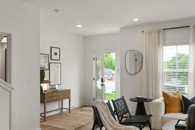 a living room with furniture a window and a potted plant