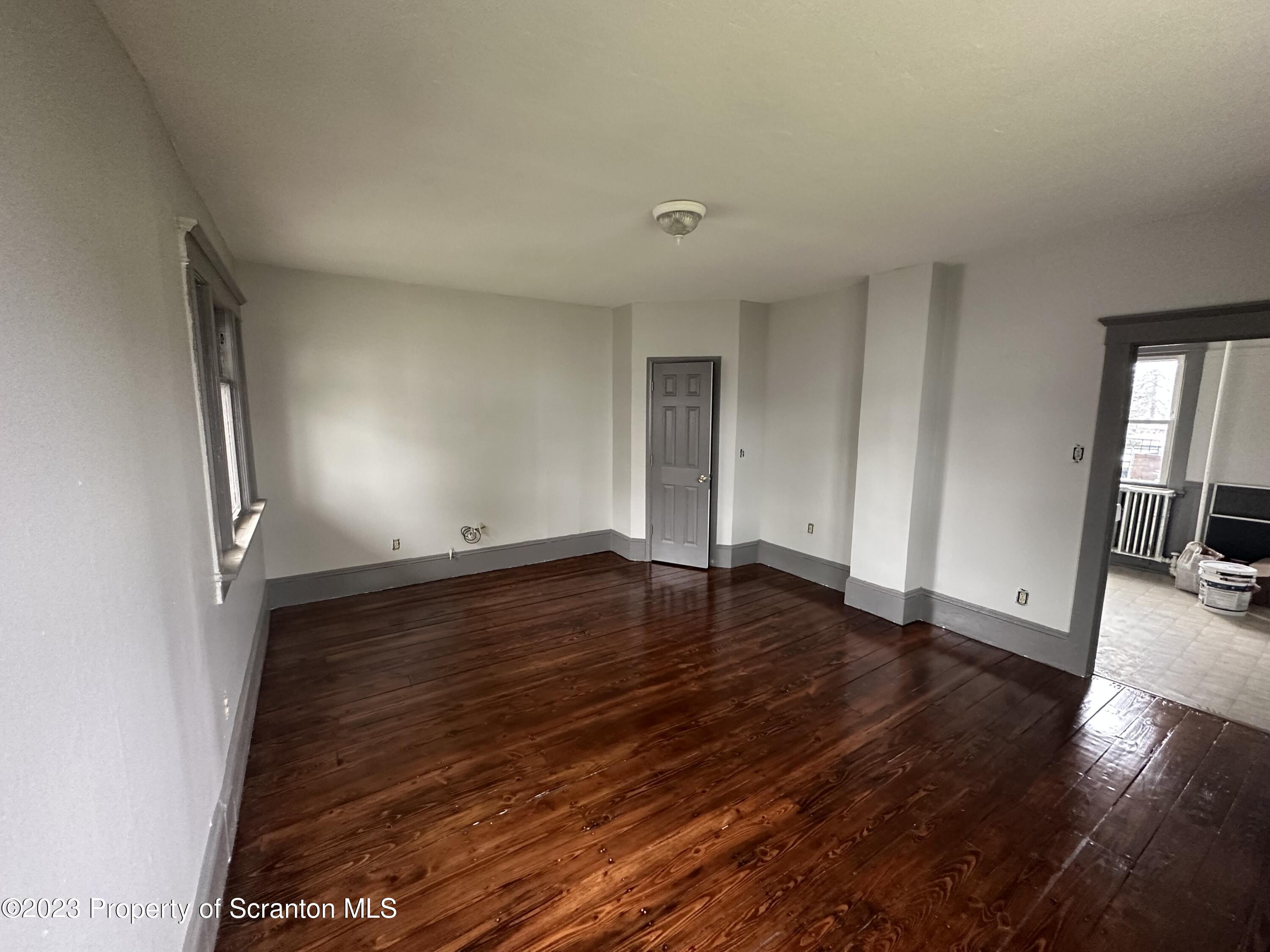 930 South Hanover Street Nanticoke, PA 18634 - Photo 2 of 9 an empty room with wooden floor and entrance