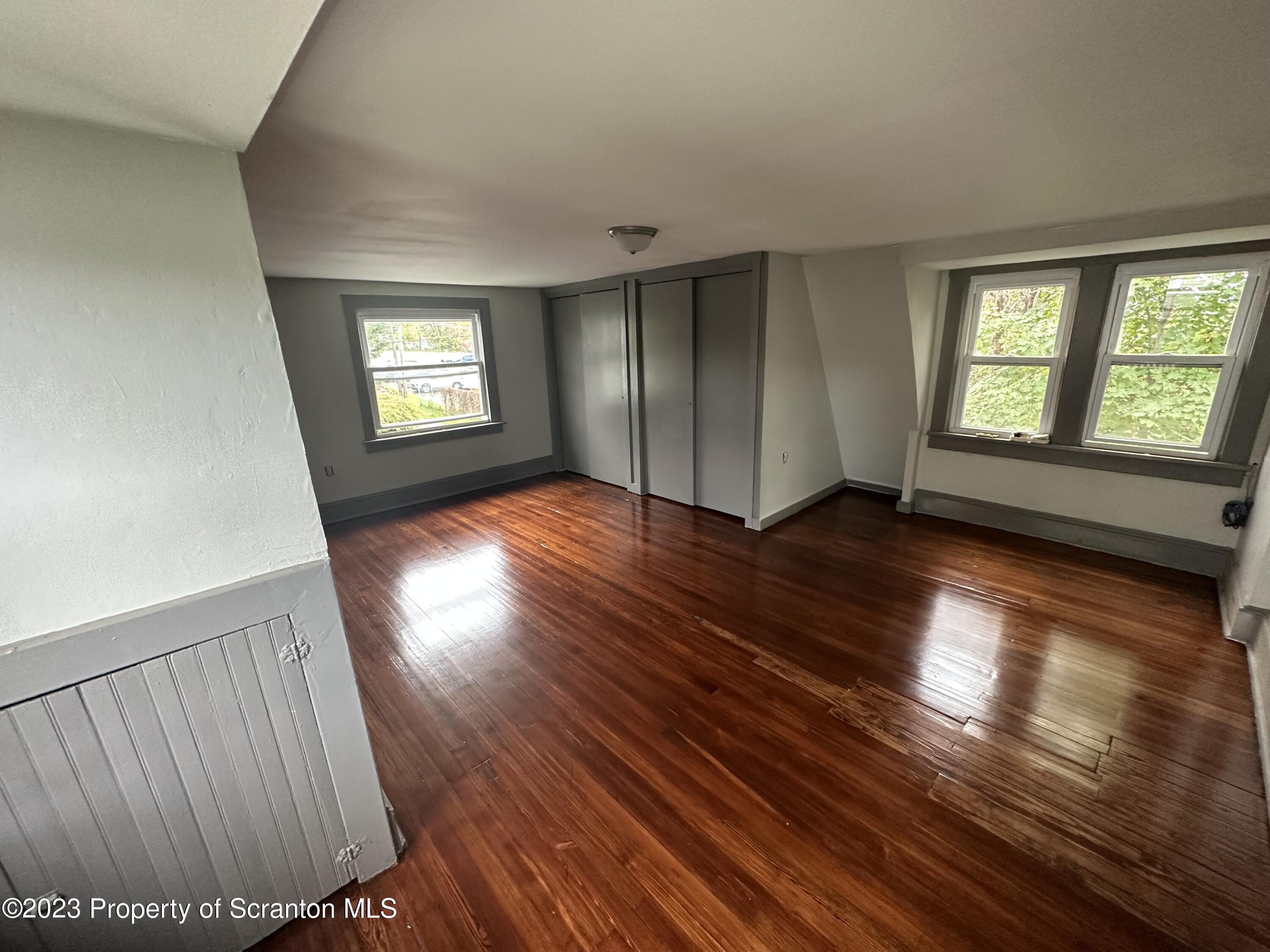 930 South Hanover Street Nanticoke, PA 18634 - Photo 7 of 9 an empty room with wooden floor and windows