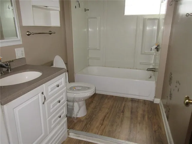 a bathroom with a granite countertop sink toilet a mirror and shower