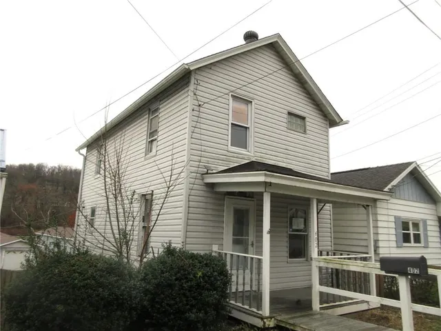 a front view of a house with plants