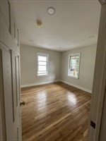 106 Rosseter Street, Unit 3 Boston, MA 02121 - Photo 5 of 9 a view of an empty room with wooden floor and a window
