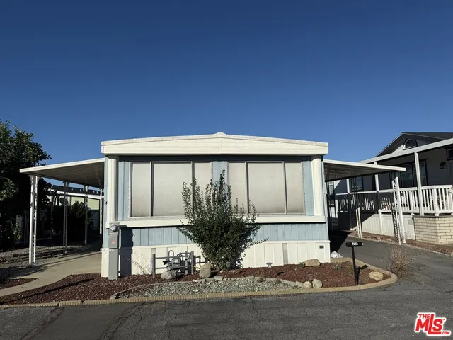 a view of a house with large windows and plants