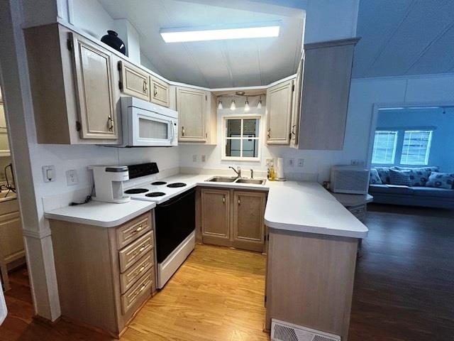 6 Robin Avenue Myrtle Beach, SC 29572 - Photo 4 of 24 Kitchen with white appliances, a peninsula, light countertops, light wood-type flooring, and lofted ceiling