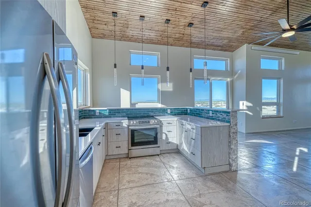 a kitchen with stainless steel appliances granite countertop a refrigerator and a stove