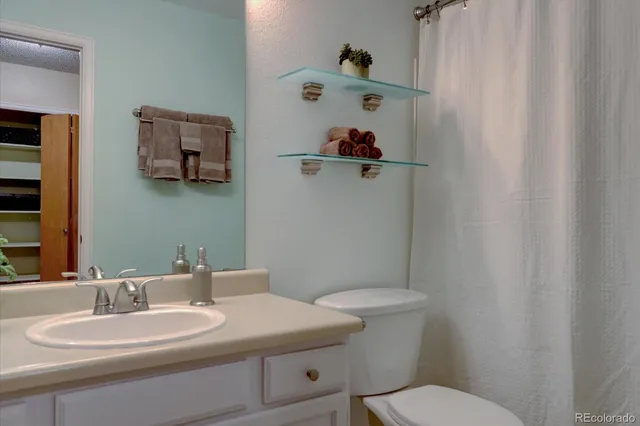 a bathroom with a sink mirror and toilet