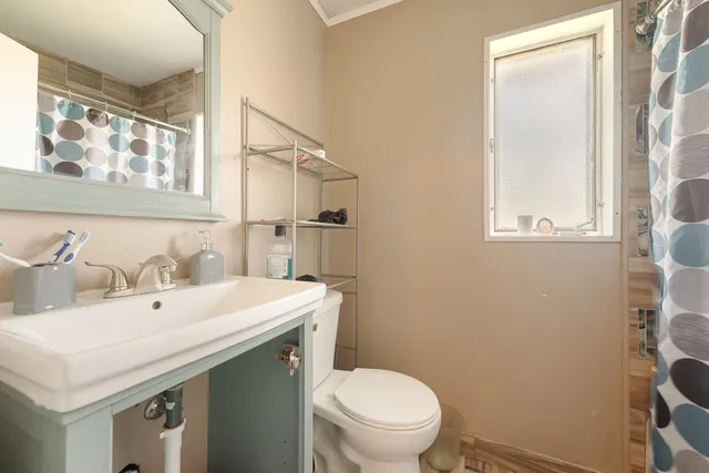 a bathroom with a toilet sink and mirror