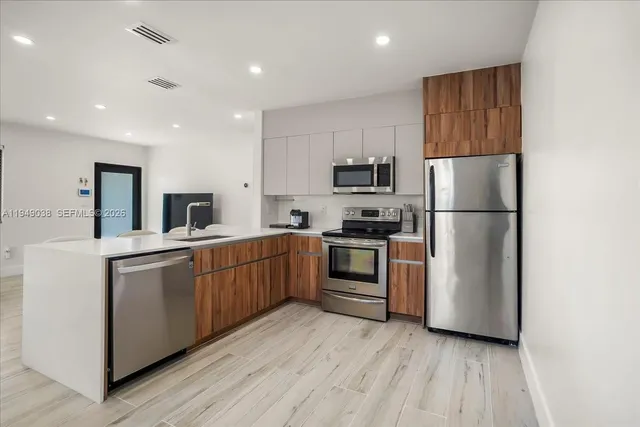 a kitchen with sink a refrigerator and white cabinets