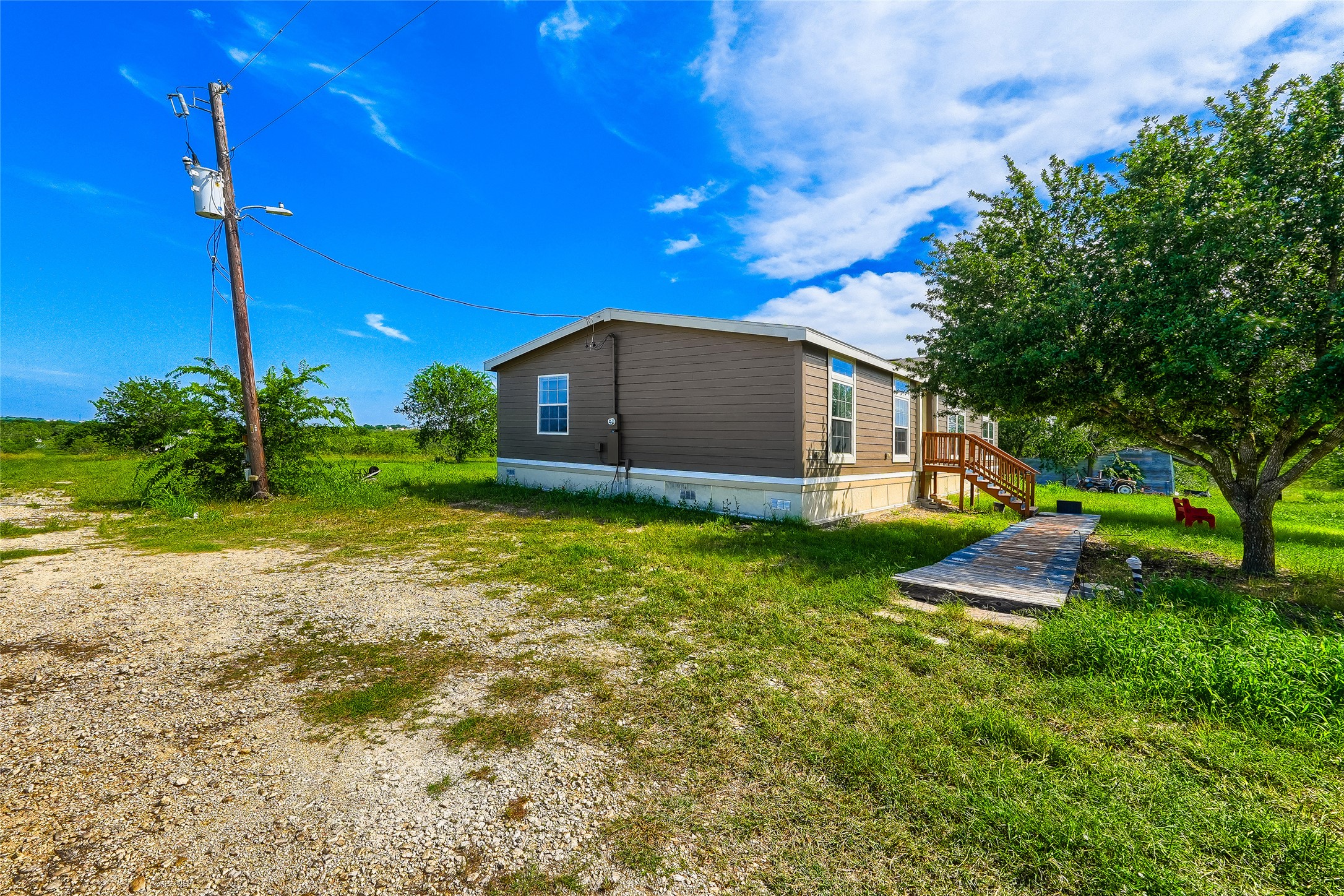 401 Graef Road Kyle, TX 78640 - Photo 24 of 30 A secluded dwelling nestled on a vast, verdant lot with a gravel driveway and mature trees.