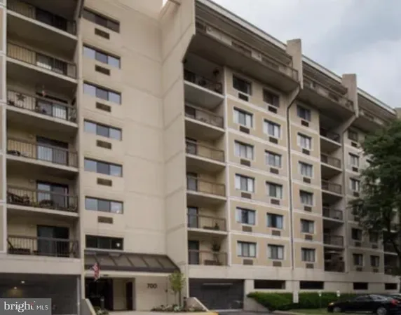 a view of swimming pool with outdoor seating and trees in the background
