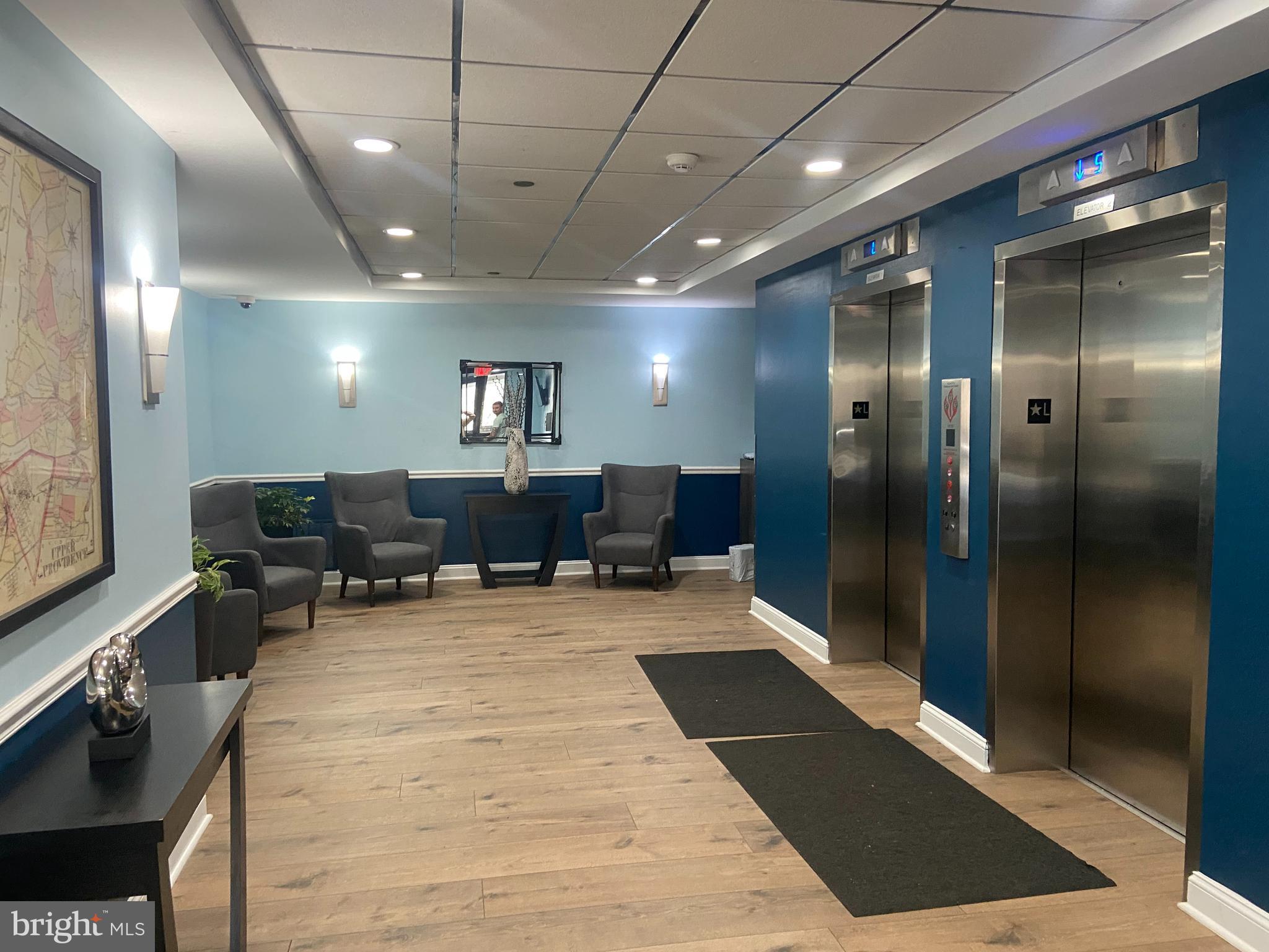 700 Avondale Road, Unit 5L Wallingford, PA 19086 - Photo 4 of 4 a large hall with stainless steel appliances lots of white furniture a rug and a large window