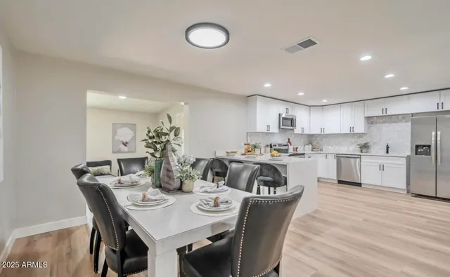a view of a dining room and kitchen with a table chairs