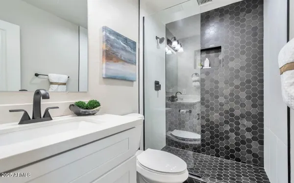 a bathroom with a sink a toilet and shower