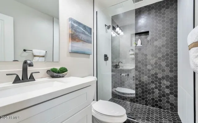 a bathroom with a sink a toilet and shower