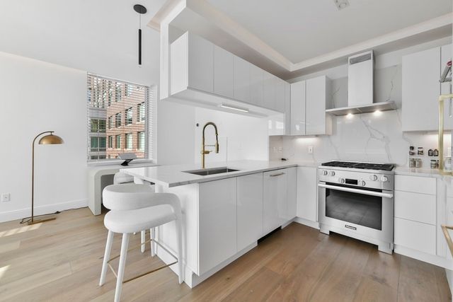 a kitchen with stainless steel appliances granite countertop a stove a sink and a refrigerator