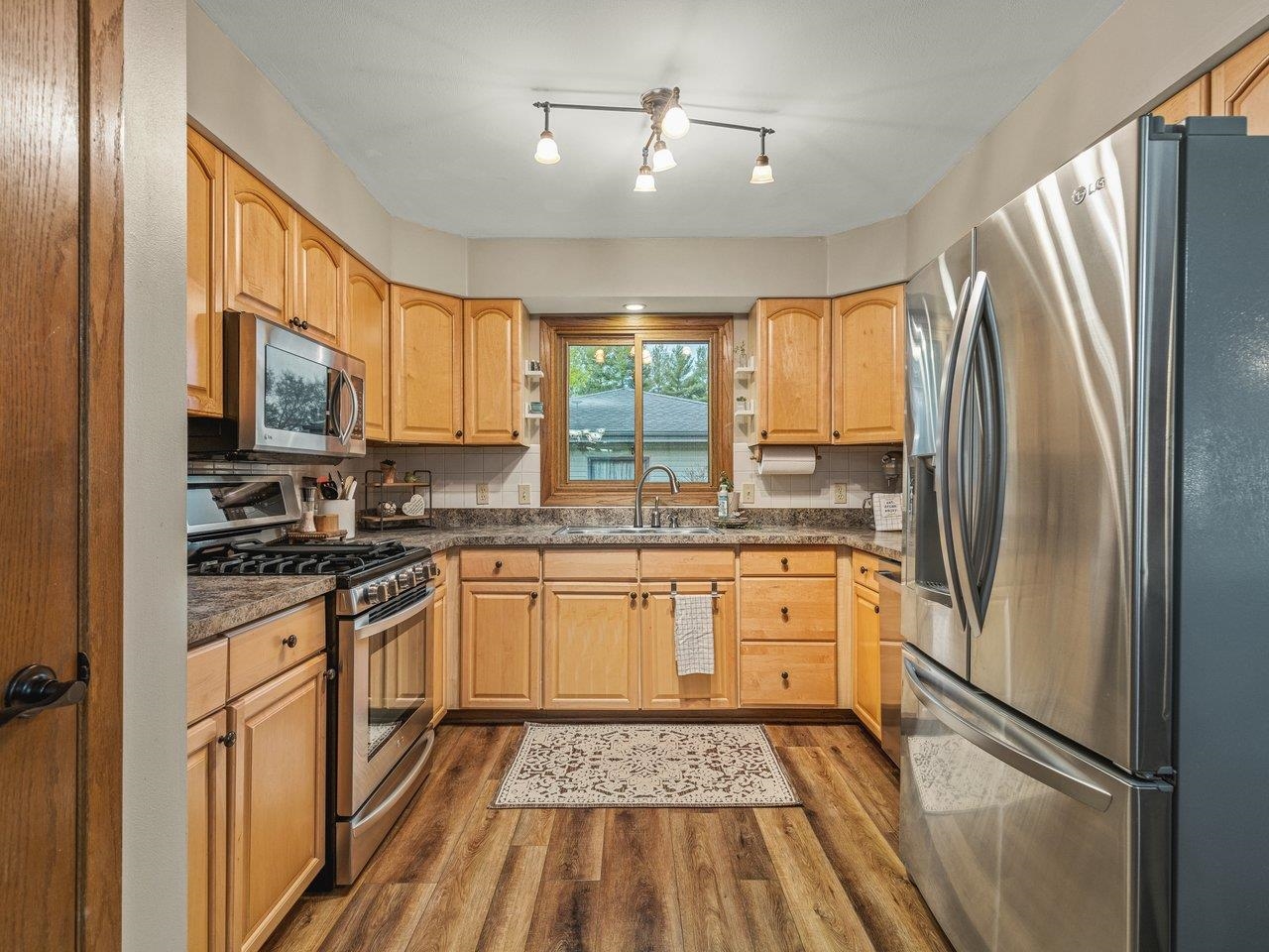 1816 Post Road Beloit, WI 53511 - Photo 14 of 42 a kitchen with stainless steel appliances granite countertop a refrigerator a stove a sink and a microwave