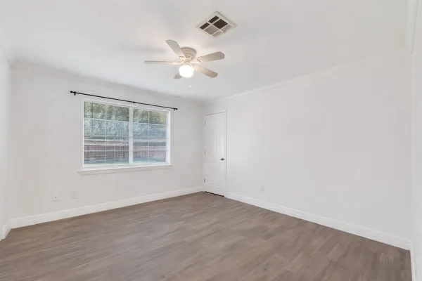 a view of an empty room with wooden floor
