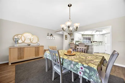 a view of a dining room with furniture a chandelier and wooden floor