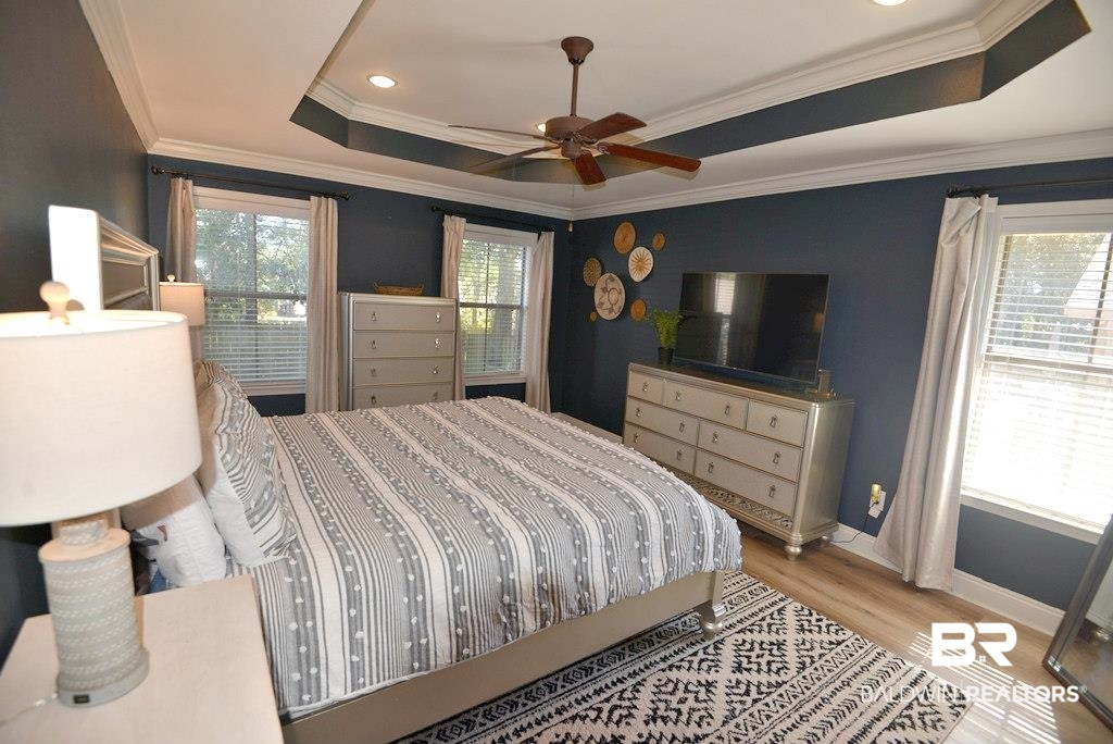 11201 Herschel Loop Daphne, AL 36526 - Photo 22 of 32 Bedroom with ornamental molding, a raised ceiling, light wood-type flooring, and ceiling fan
