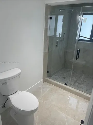 a bathroom with a toilet and a shower