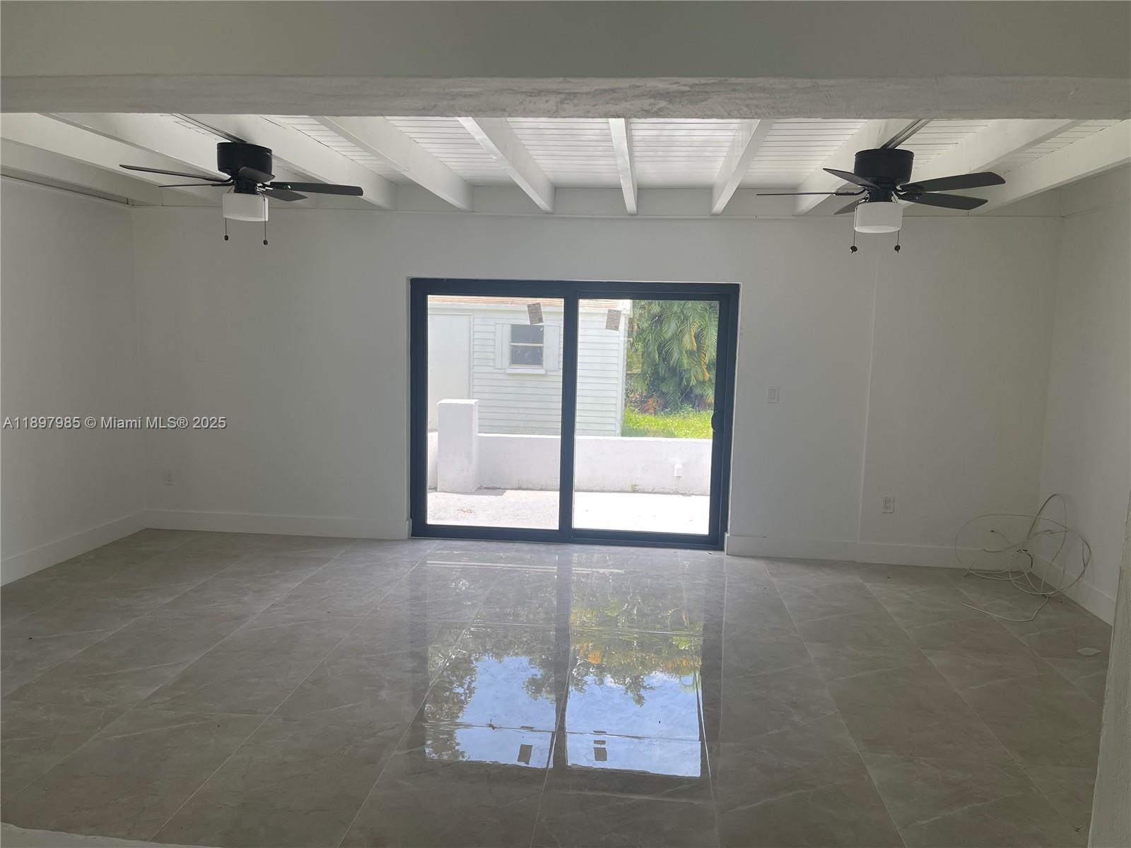 4310 Northwest 182nd Street Miami Gardens, FL 33055 - Photo 5 of 12 an empty room with windows and fan