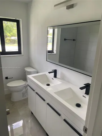 a bathroom with a sink a toilet and mirror
