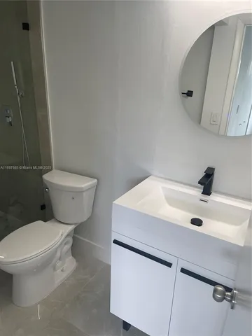 a white toilet sitting next to a bathroom sink