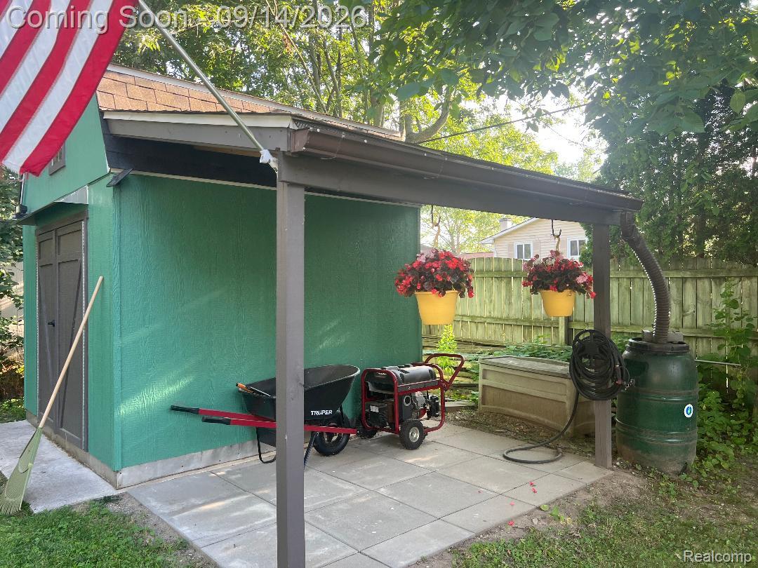 1615 Ladd Road Walled Lake, MI 48390 - Photo 23 of 28 Detached storage shed with a shingle roof and a covered patio area featuring concrete paver flooring